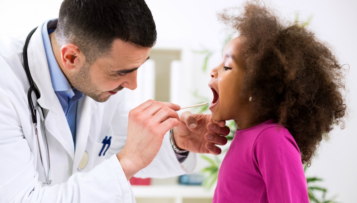 Locum tenens pediatrician examining girl's throat