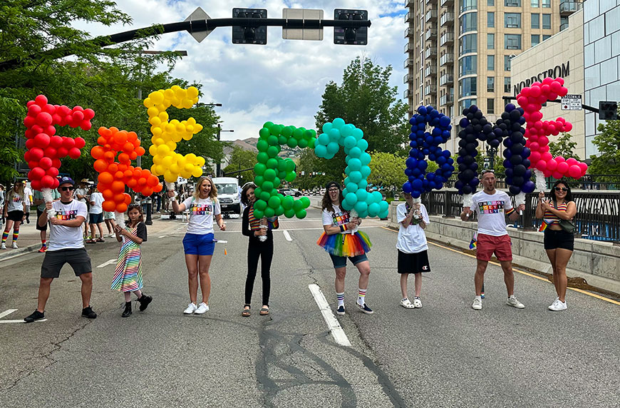 CHG employees celebrate Pride Month with balloons that read Free 2 B Me